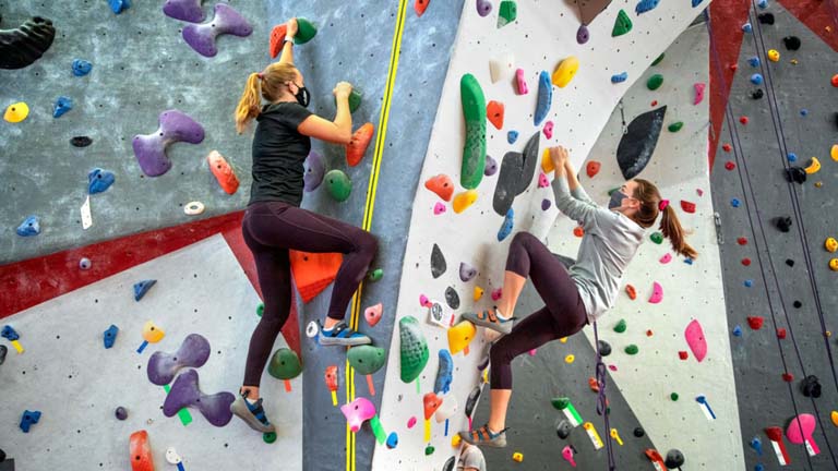 Students climbing in a climbing wall.