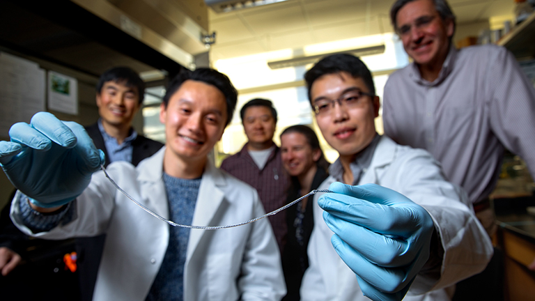 Doctoral students Alan Chiu, left, and Duo An hold a sample of TRAFFIC (Thread-Reinforced Alginate Fiber for Islets enCapsulation).