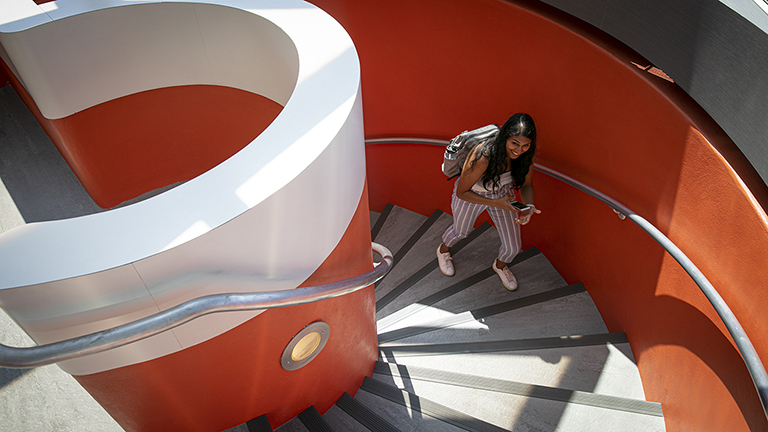 A student climbs the circular staircase into Uris Library from the Cocktail Lounge.
